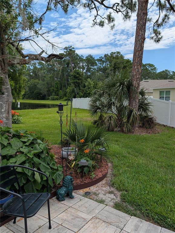 A two-story townhouse exterior features beige siding, two garage doors, and a for sale sign — 136 BAYTREE BOULEVARD, TAVARES, FL