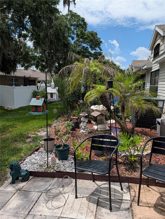 The exterior of a house features light-colored siding, a palm tree, and a house number — 136 BAYTREE BOULEVARD, TAVARES, FL
