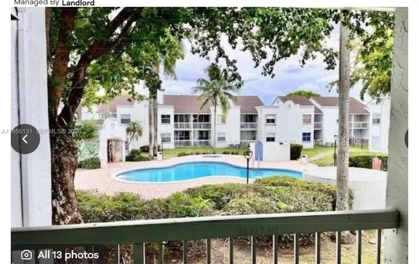 A view from a balcony overlooking a swimming pool surrounded by apartment buildings and trees — 4654 NW 97th Ct # 95, Doral FL 33178, DORAL, FL