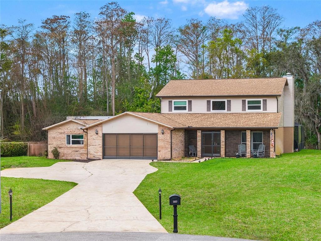 A two-story house with a brick and siding exterior, a garage, and a concrete driveway — 1357 DINSMORE COURT, NEW PORT RICHEY, FL