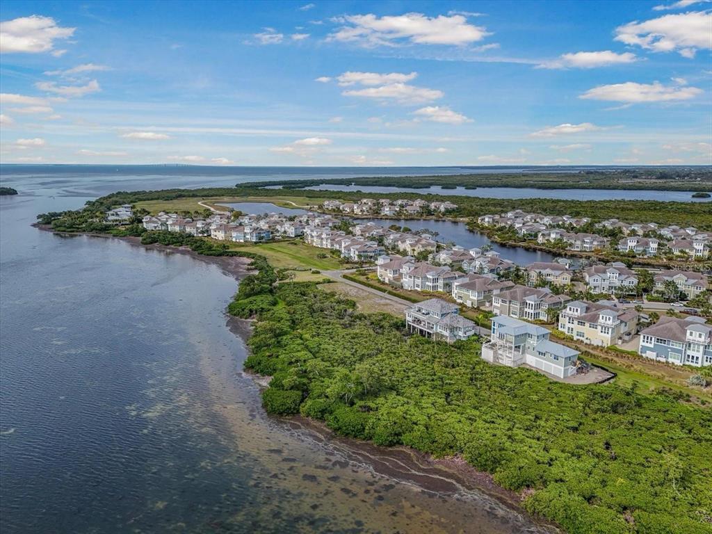 An aerial view shows a coastal residential community surrounded by mangroves and open water — 324 HARBOUR SOUND COURT, BRADENTON, FL
