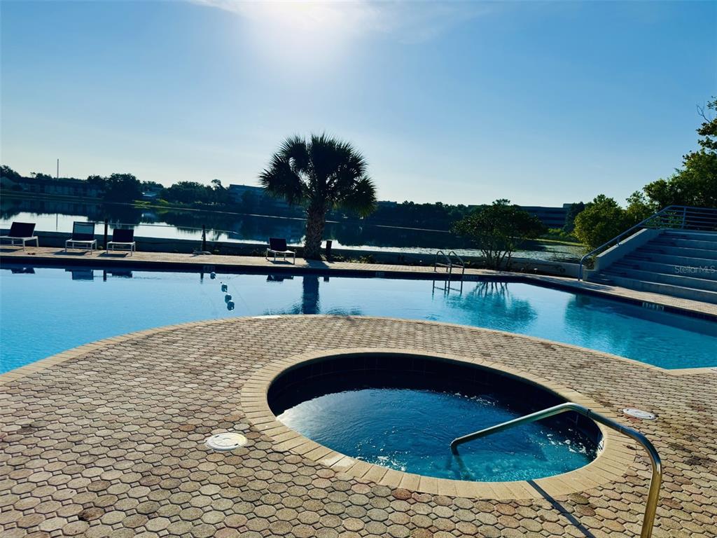 A view of a lake with lily pads, a large office building, and residential houses — 1000 WINDERLEY PLACE UNIT 128, MAITLAND, FL