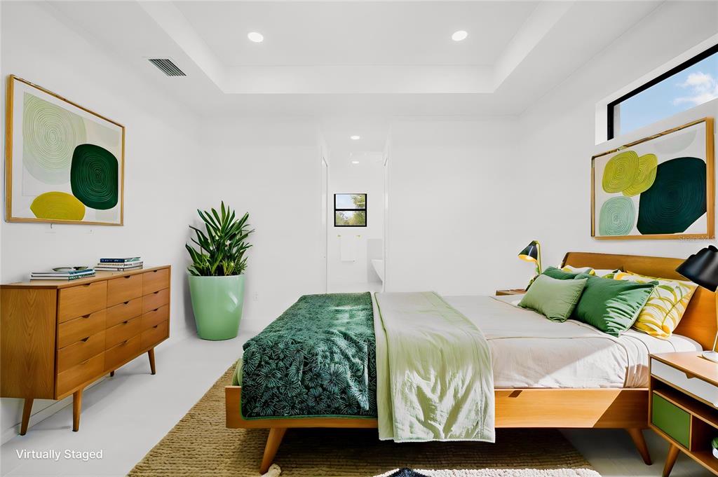 A bedroom with a tray ceiling, mid-century modern furniture, and green-toned decor — 1270 MILIKEN TERRACE, PORT CHARLOTTE, FL