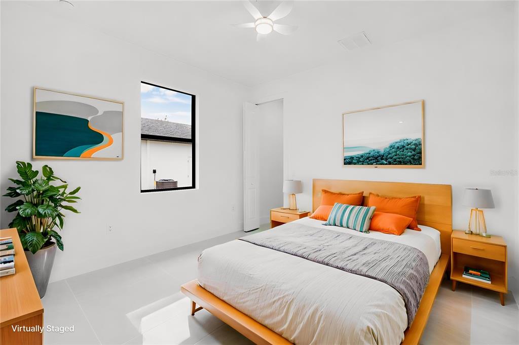 A bedroom with a bed, two nightstands, and a window, featuring white tile flooring — 1270 MILIKEN TERRACE, PORT CHARLOTTE, FL