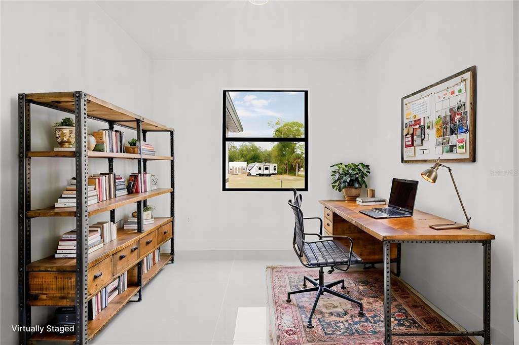 A home office features a wooden desk, matching bookshelf, and a window overlooking a yard — 1270 MILIKEN TERRACE, PORT CHARLOTTE, FL
