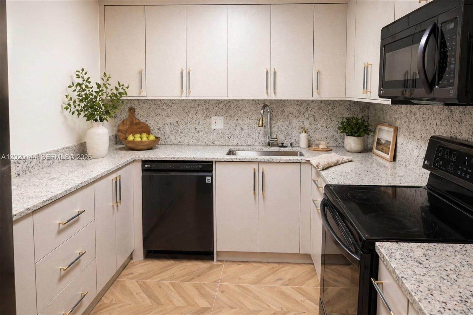 A kitchen features light-colored cabinets, granite countertops, a black dishwasher, and a black stove — 2500 Parkview Dr # 1816, Hallandale Beach FL 33009, HALLANDALE BEACH, FL