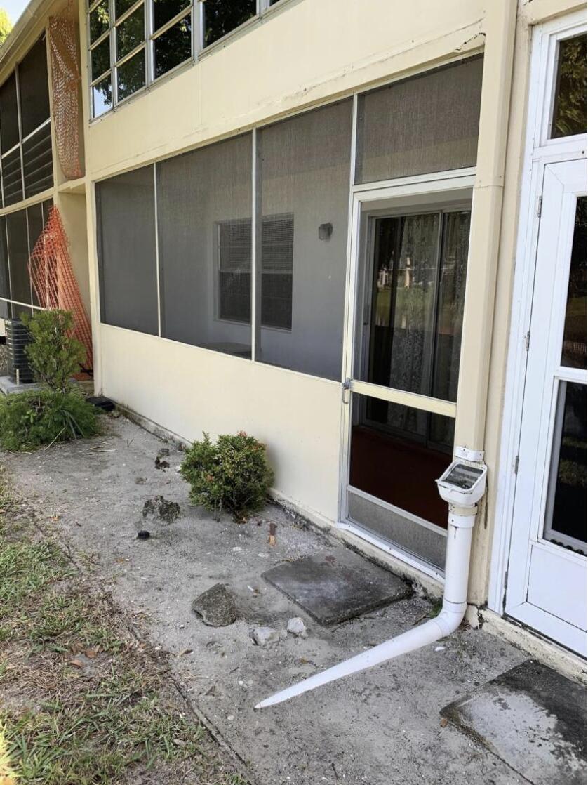 A exterior view of a building entrance with a louvered glass door numbered 74 — 74 Sheffield D, West Palm Beach FL 33417, WEST PALM BEACH, FL