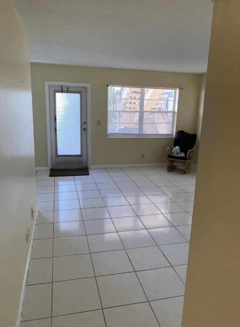 A kitchen with white cabinets, a white stove, a refrigerator, and tiled countertops and floors — 74 Sheffield D, West Palm Beach FL 33417, WEST PALM BEACH, FL