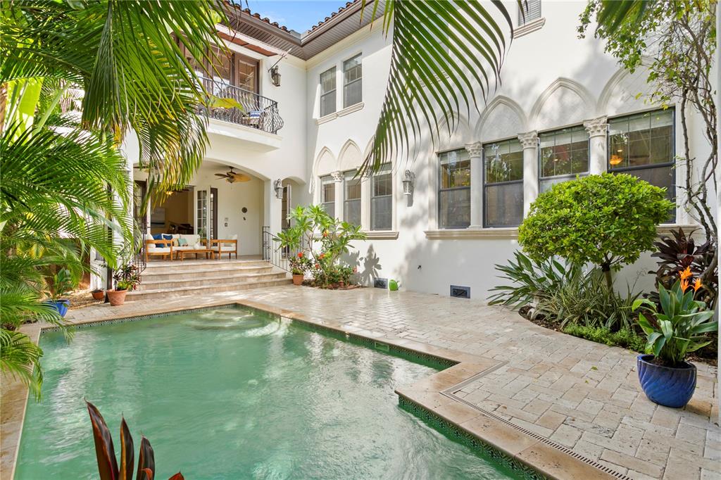 A swimming pool sits in a stone-paved courtyard beside a white two-story Mediterranean-style home — 601 BOSPHOROUS AVENUE, TAMPA, FL