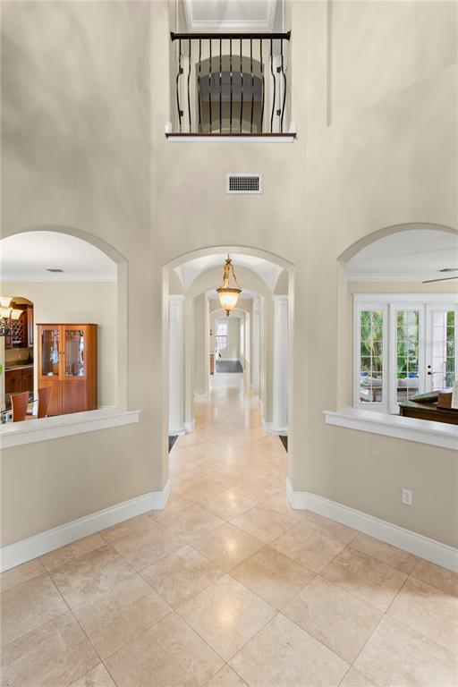 A tiled foyer features arched openings, a central hallway, and an upper-level balcony railing — 601 BOSPHOROUS AVENUE, TAMPA, FL