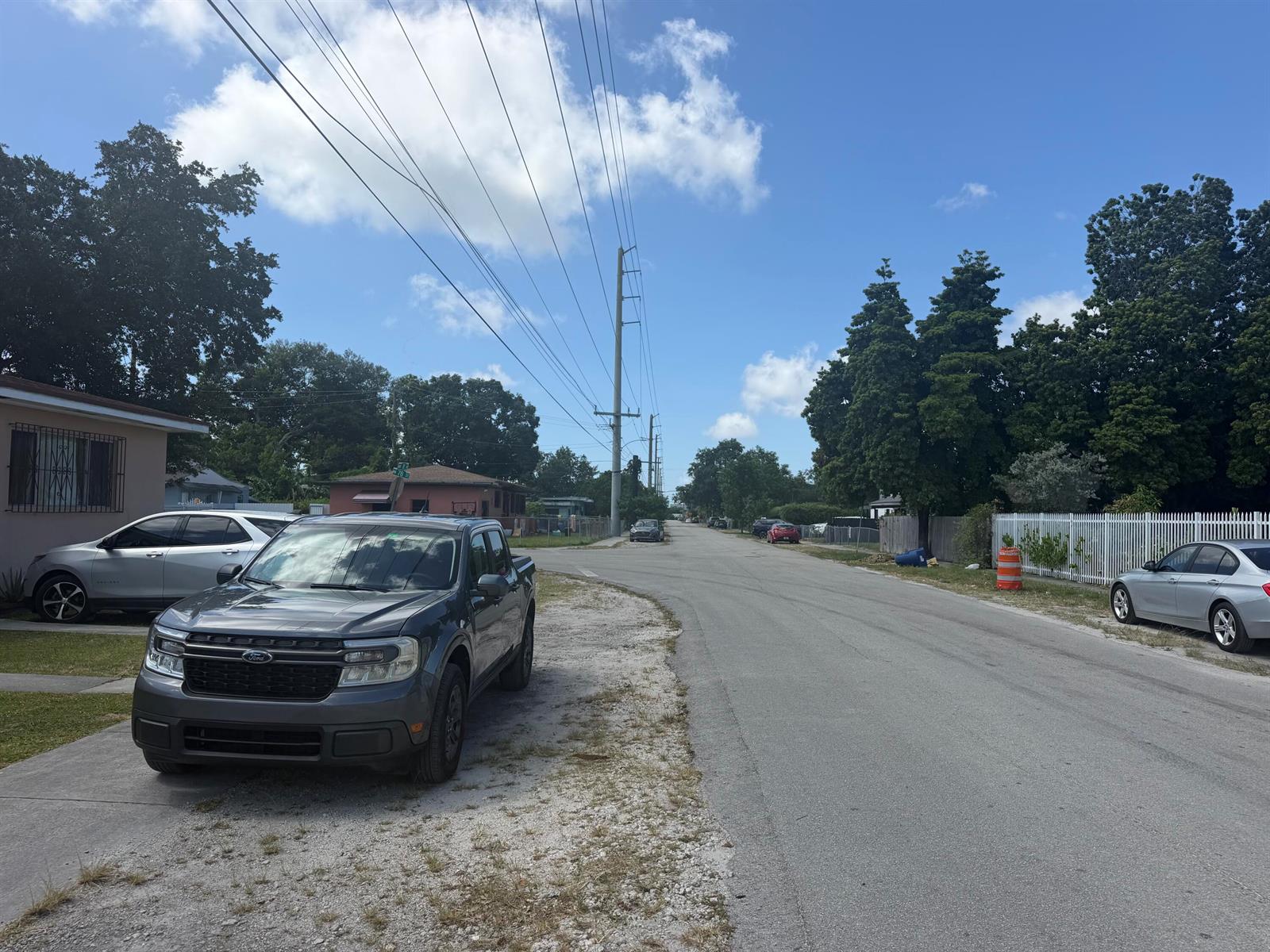 A gray pickup truck is parked on a gravel driveway next to a residential street — 7803 NW 8th Avenue, Miami FL 33150, MIAMI, FL