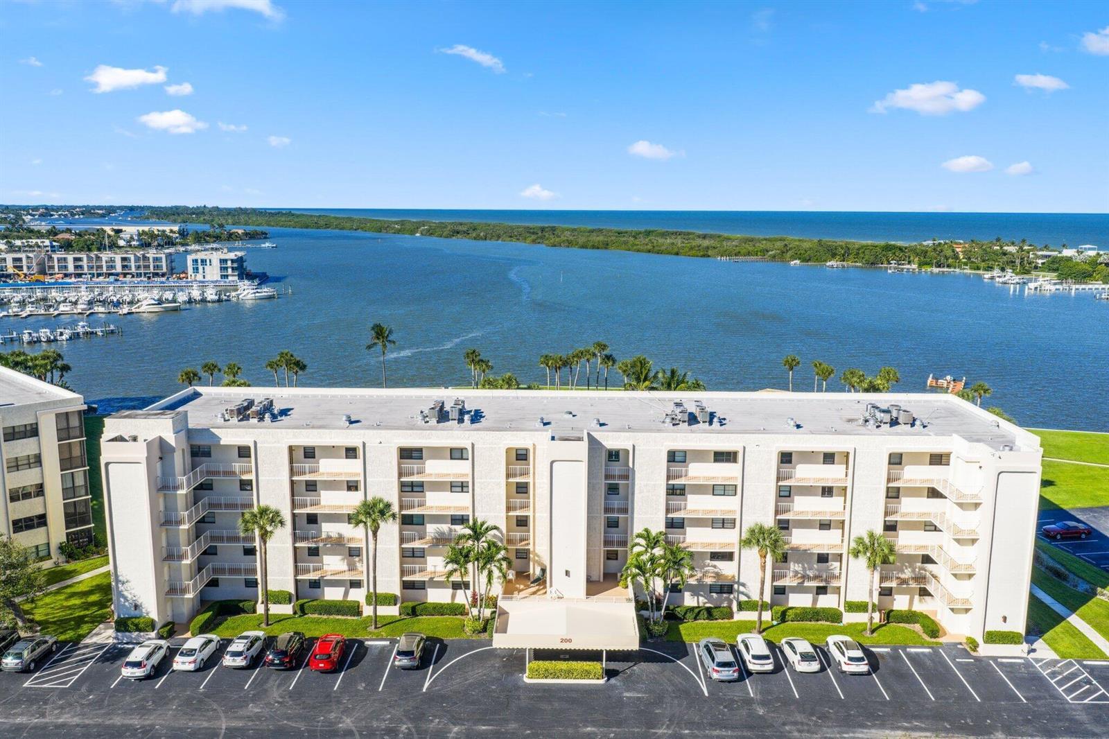 An aerial view of a multi-story apartment building with a parking lot and waterfront view — 200 Intracoastal Place # 206, Jupiter FL 33469, JUPITER, FL