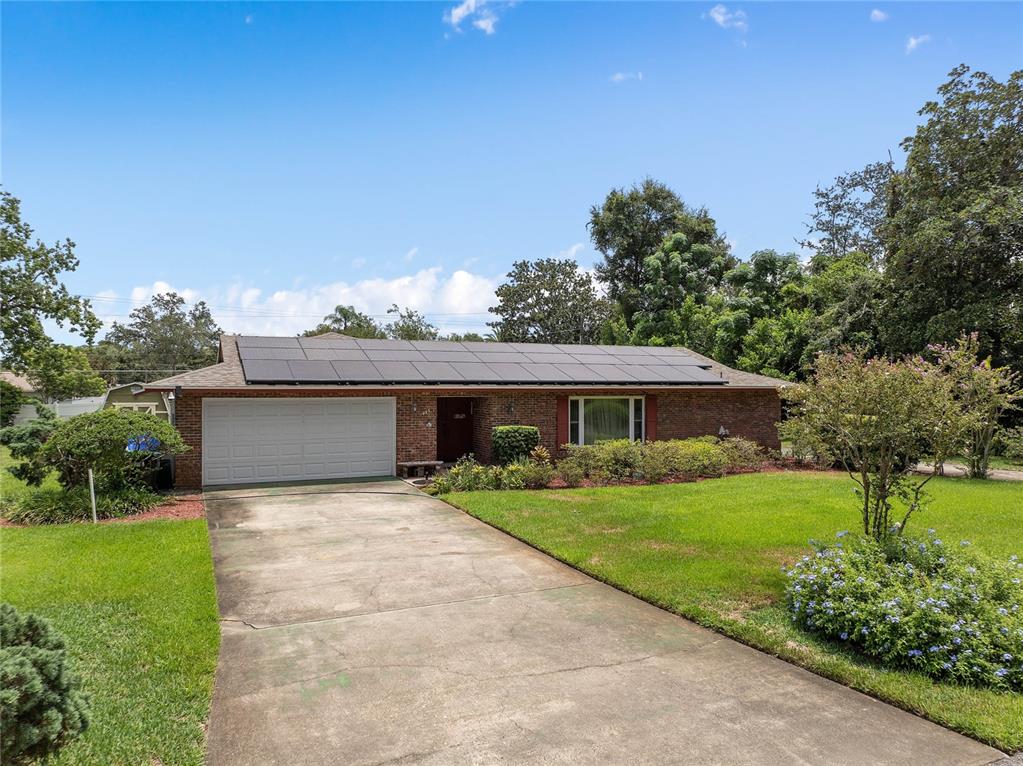 An aerial view shows a single-story house with solar panels on the roof and yard — 1435 PAULA DRIVE, APOPKA, FL