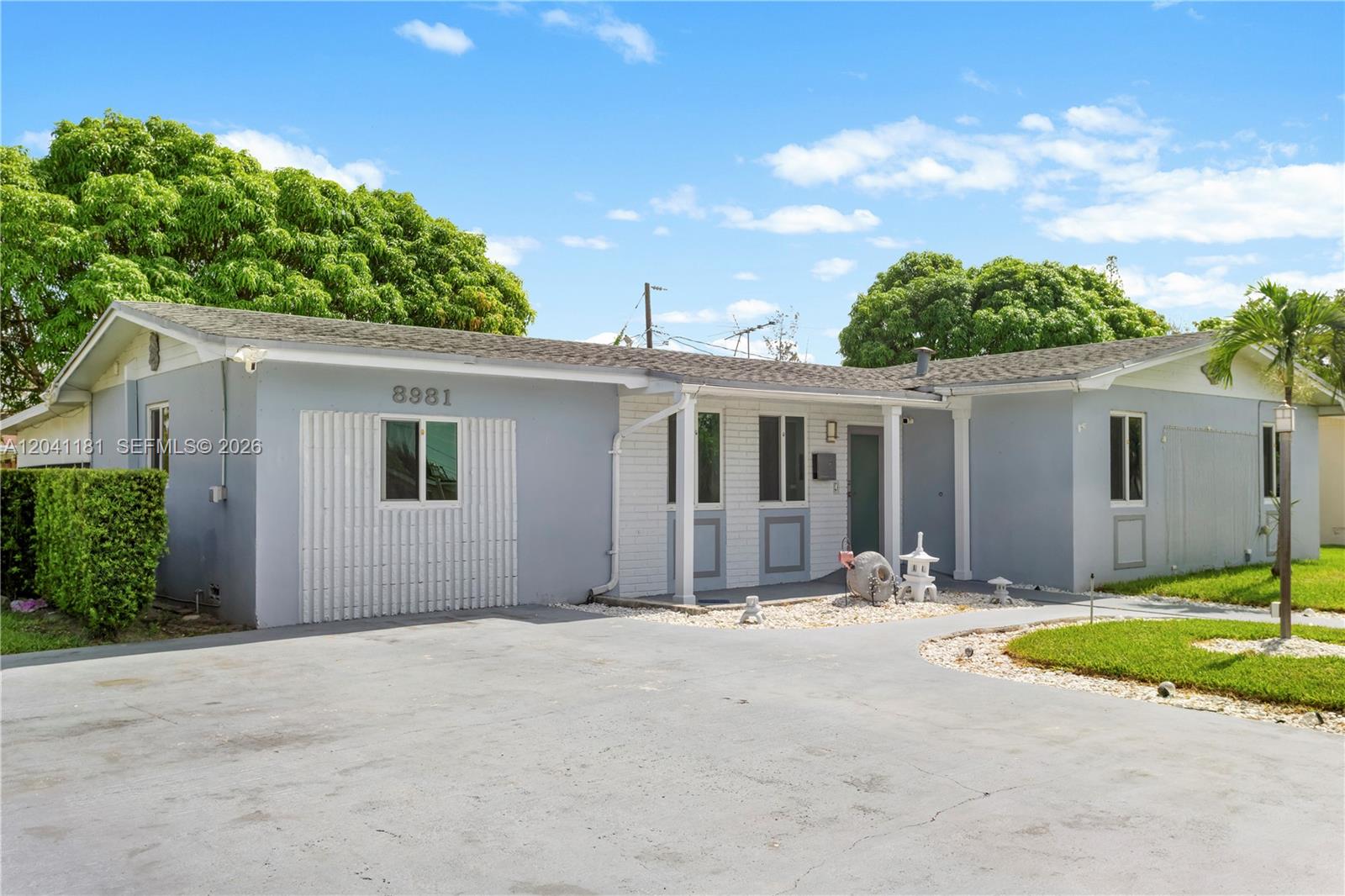 A single-story house with a light gray exterior, white brick accents, and a paved driveway — 8981 SW 127th Ter, Miami FL 33176, MIAMI, FL