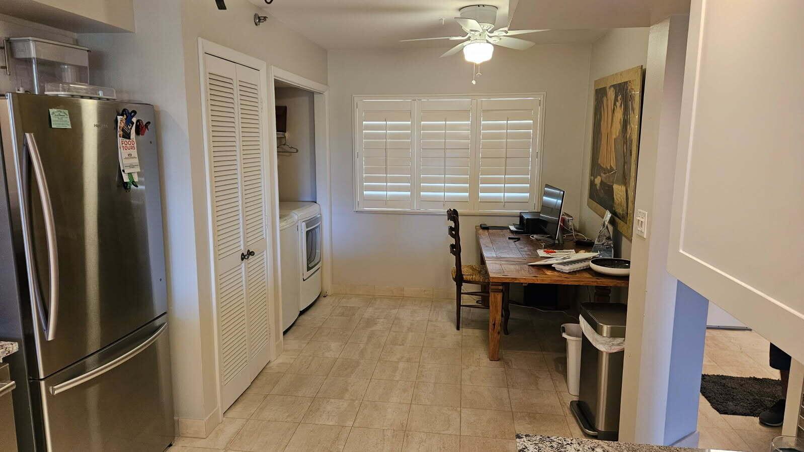 A kitchen area features a stainless steel refrigerator, laundry closet, and a wooden desk — 500 Ocean Trail Way # 307, Jupiter FL 33477, JUPITER, FL