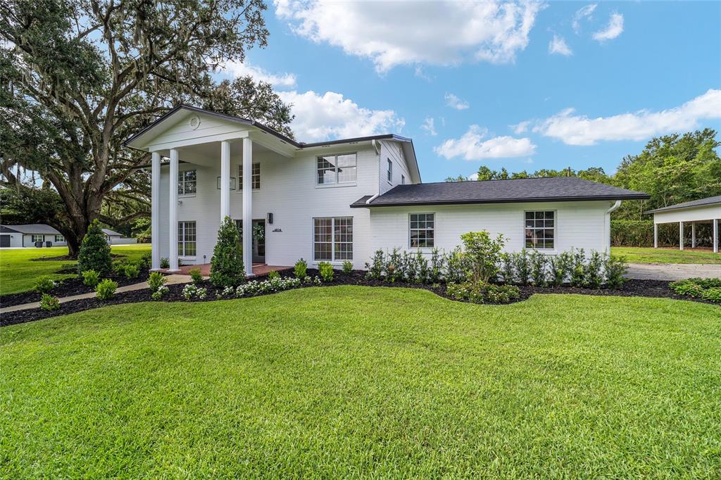 A white two-story house with a columned front porch stands on a grassy lawn — 4824 SE 3RD STREET, OCALA, FL