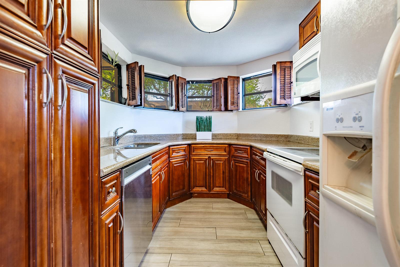 A kitchen features wood cabinets, granite countertops, stainless steel appliances, and a bay window — 9375 SW 61st Way SW # D, Boca Raton FL 33428, BOCA RATON, FL