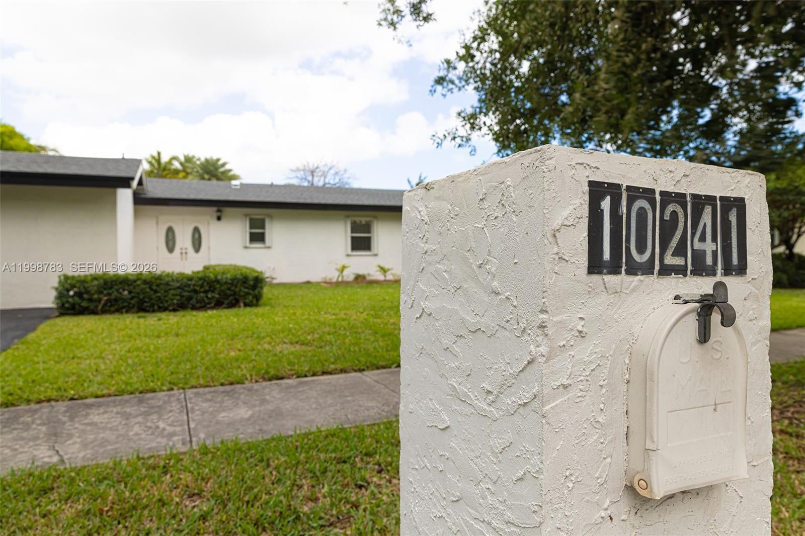 A white stucco mailbox with house numbers stands in front of a single-story residential home — 10241 SW 128th Ave, Miami FL 33186, MIAMI, FL