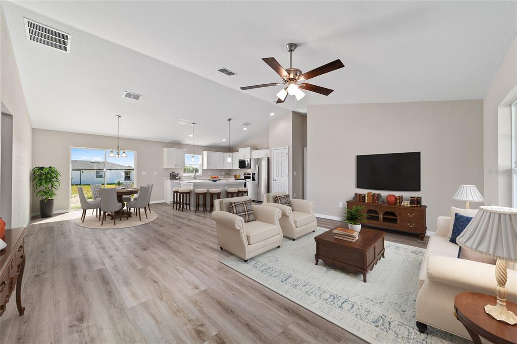 An open-concept living room and kitchen feature light wood flooring and neutral walls — 15159 SW 29TH STREET, OCALA, FL
