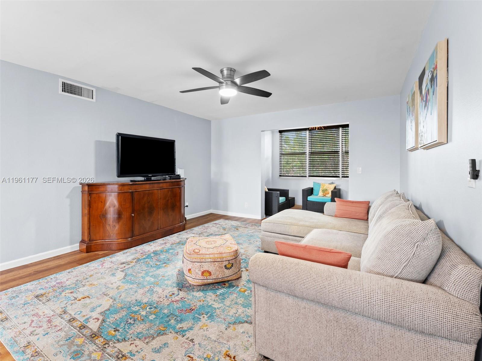 A living room features a sectional sofa, a wooden media console, and a patterned rug — 2601 NE 3rd Ct # 4030, Boynton Beach FL 33435, BOYNTON BEACH, FL