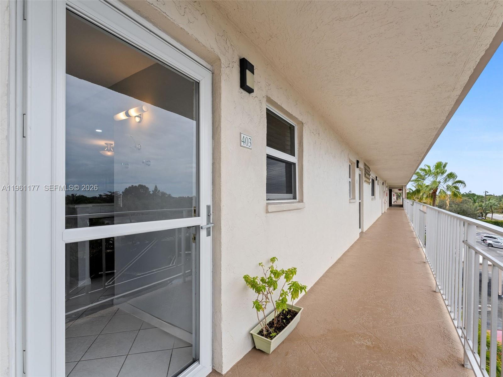 An exterior walkway leads past a glass door and a window labeled 403 — 2601 NE 3rd Ct # 4030, Boynton Beach FL 33435, BOYNTON BEACH, FL