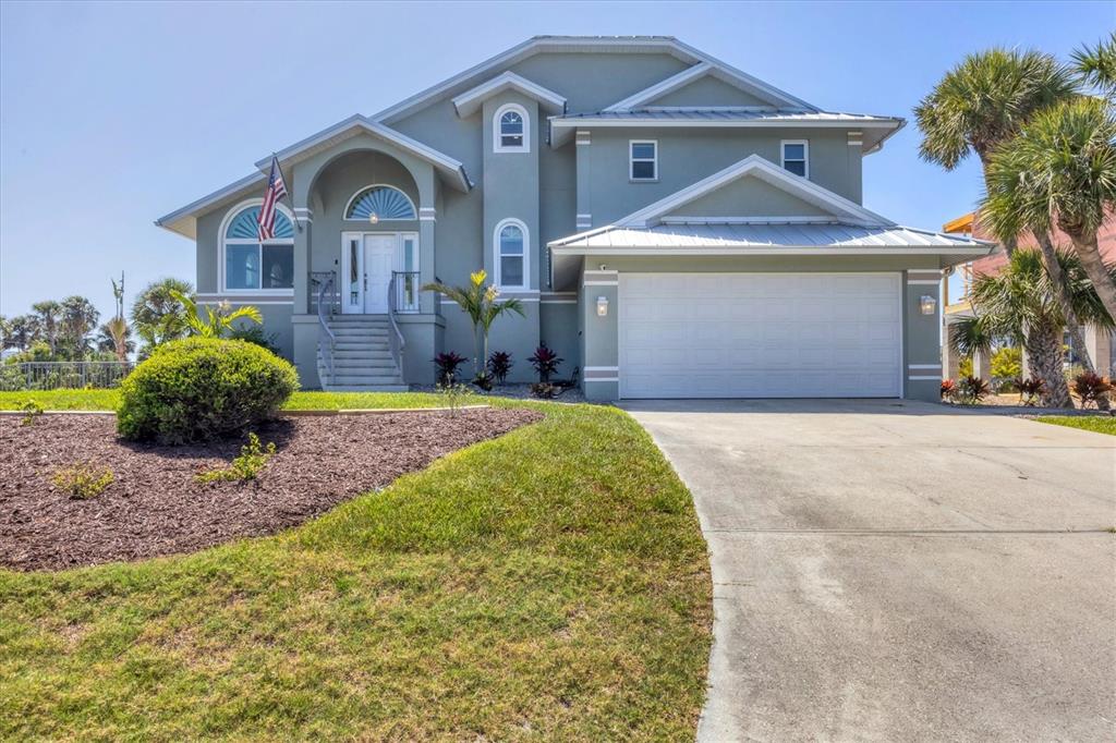 A two-story house with a light green exterior, a white garage door, and a front staircase — 10500 SHERMAN STREET, ENGLEWOOD, FL
