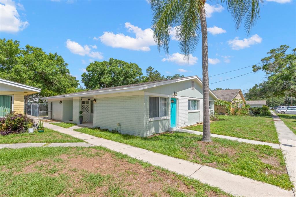 A light green, single-story brick house with a bright blue front door and palm tree — 415 MAPLE WAY UNIT A & B, SAFETY HARBOR, FL