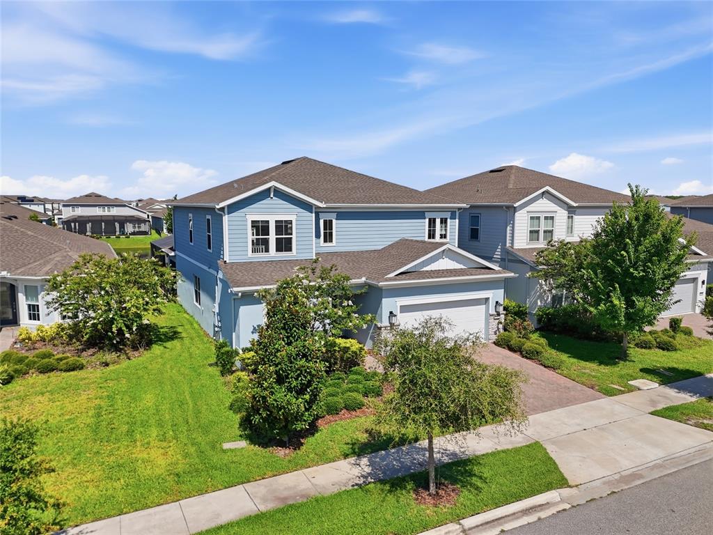 An aerial view of a two-story blue house with a shingled roof and attached garage — 13932 DESTIN BEACH LANE, ORLANDO, FL