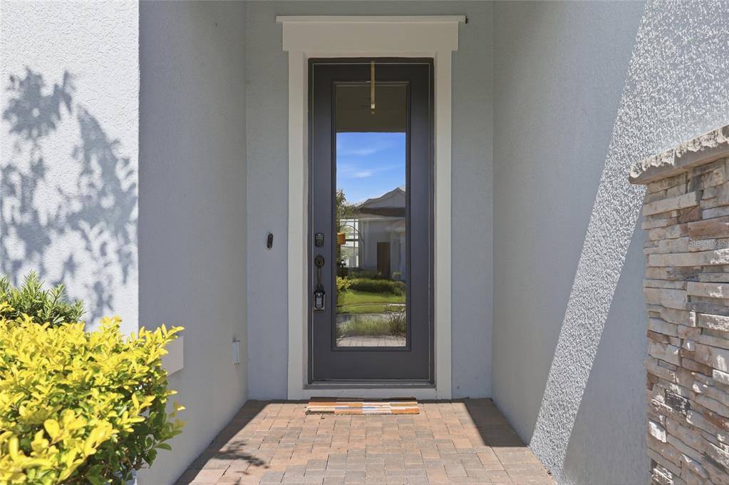 A dark gray front door with a glass panel is set in a recessed entryway — 13932 DESTIN BEACH LANE, ORLANDO, FL