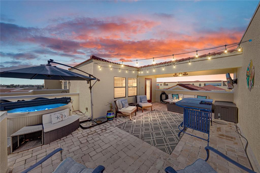 A rooftop patio features a hot tub, outdoor seating, a fire pit, and string lights — 6411 MAYRA SHORES LANE, APOLLO BEACH, FL