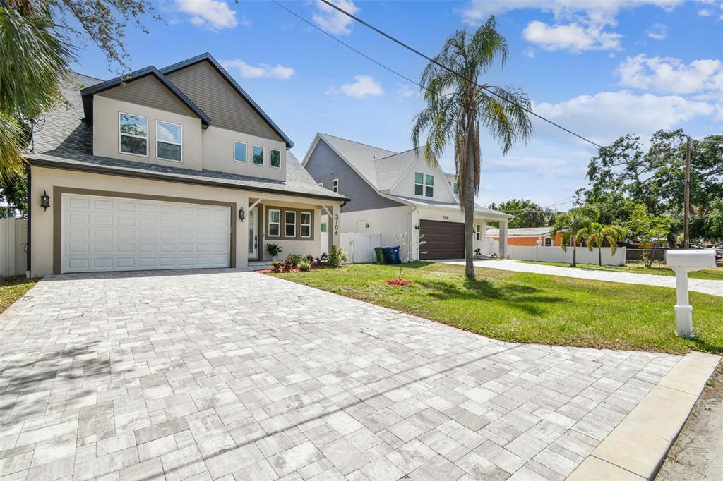 A two-story house with a paved driveway and a garage next to a similar home — 3106 W CHEROKEE AVENUE, TAMPA, FL