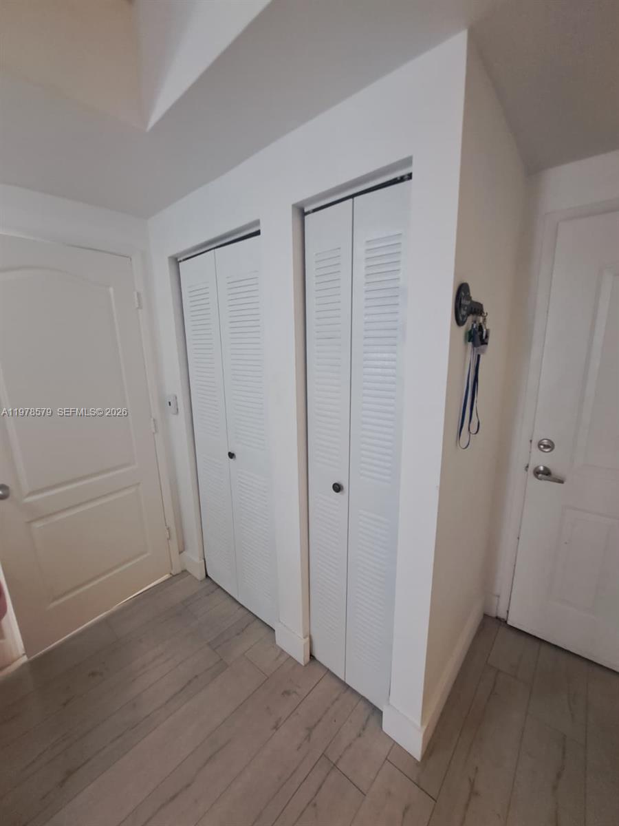 This interior view shows two white louvered closet doors and light-colored wood-look flooring — 5077 NW 7th St # 912, Miami FL 33126, MIAMI, FL