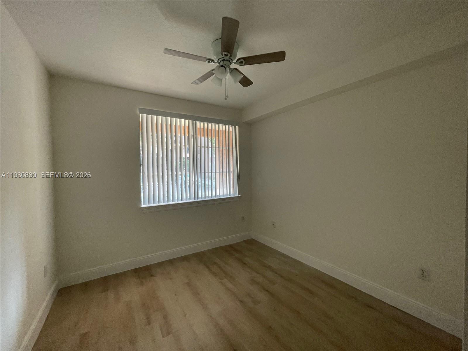 An empty bedroom features light wood-look flooring, white walls, and a ceiling fan — 6821 SW 44th St # 301, Miami FL 33155, MIAMI, FL
