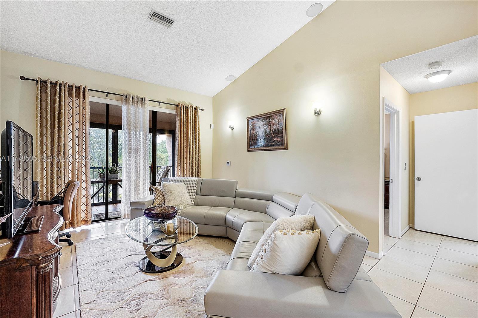 A kitchen features white cabinets, stainless steel appliances, and a mosaic tile backsplash — 4101 E Coral Tree Cir # 313, Coconut Creek FL 33073, COCONUT CREEK, FL