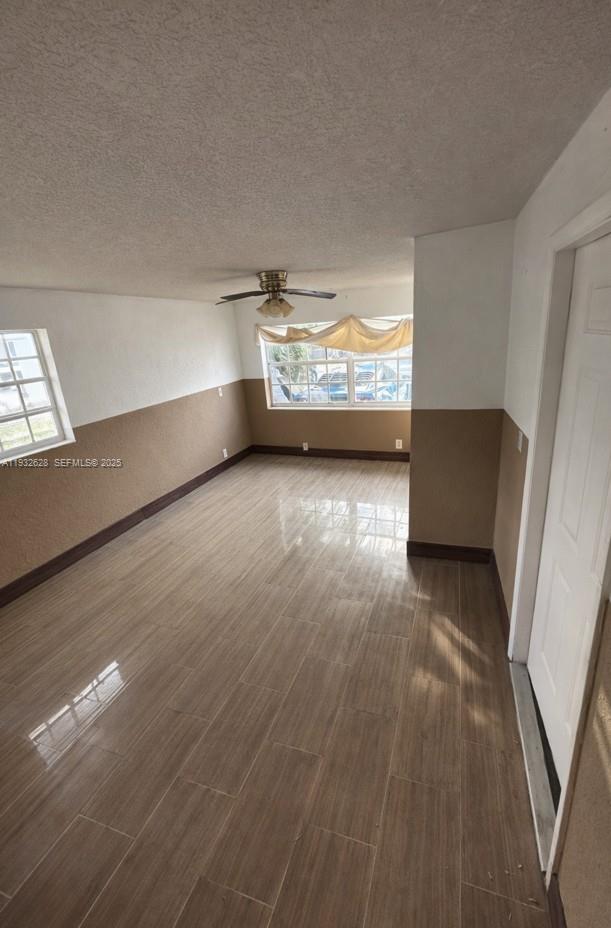 An empty room features light-colored tile flooring, two-toned walls, and a ceiling fan — 14405 NE 5th Ave # B, Miami FL 33161, MIAMI, FL