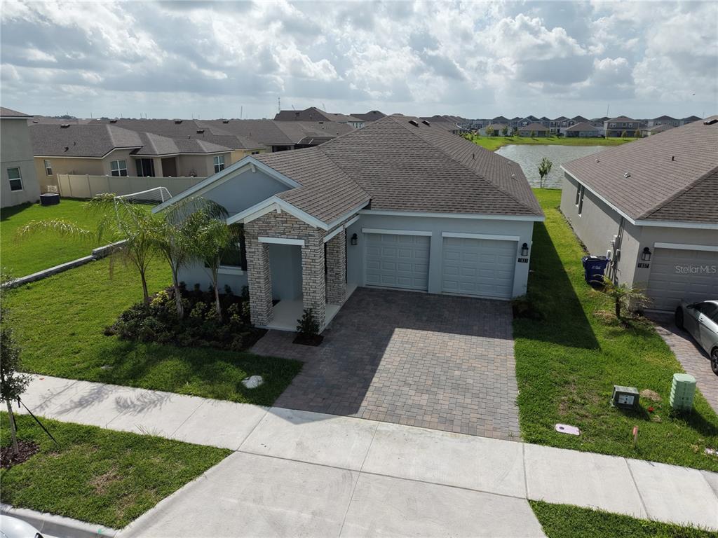 An aerial view of a single-story house with a stone-accented entryway and two-car garage — 1831 BRIGHT SKY DRIVE, KISSIMMEE, FL