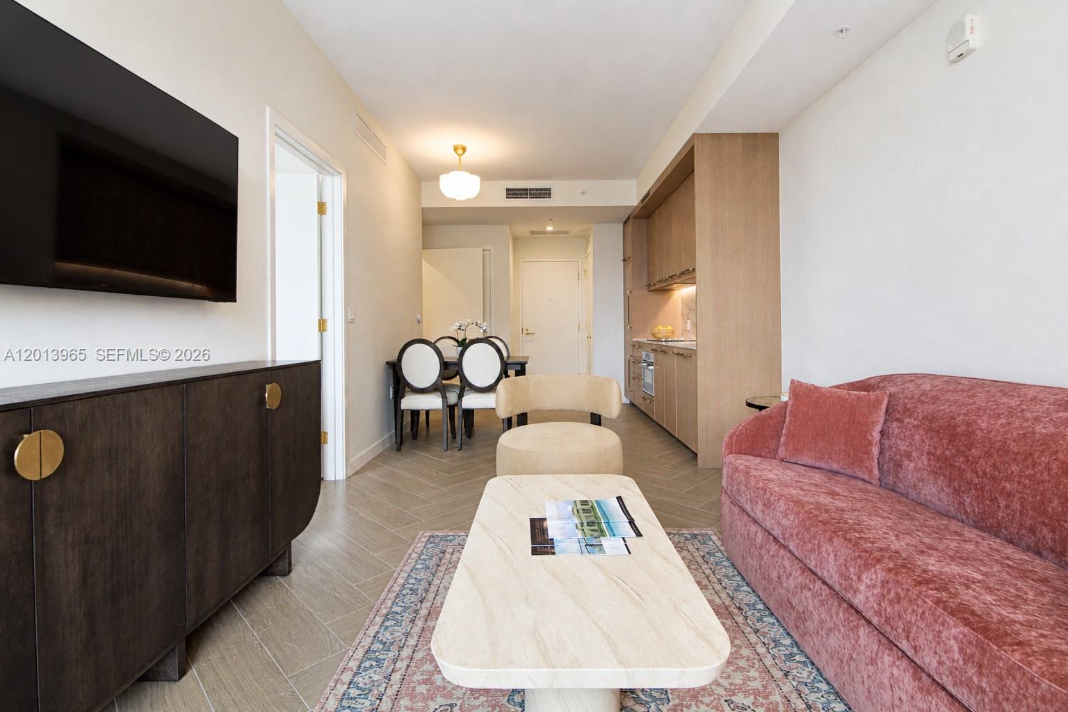 A living room features a pink sofa, a stone coffee table, and a dining area — 2700 NW 2nd Ave # 202, Miami FL 33127, MIAMI, FL