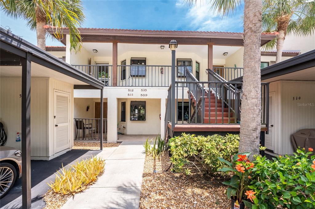 An exterior view of a two-story apartment building with a staircase and walkway — 511 PINE HOLLOW CIRCLE UNIT 511, ENGLEWOOD, FL