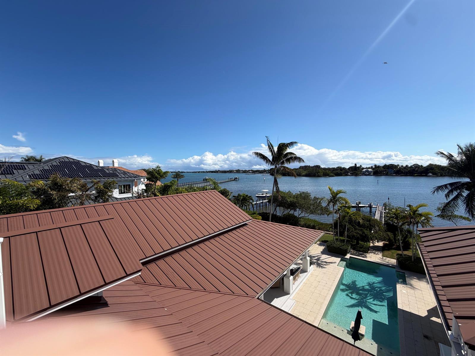 An elevated view shows a metal roof, a swimming pool, and a waterfront landscape — 5270 Pennock Point Road, Jupiter FL 33458, JUPITER, FL