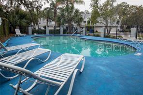 An outdoor swimming pool surrounded by lounge chairs on a blue deck — 9726 TIFFANY OAKS LANE UNIT 9726, TAMPA, FL