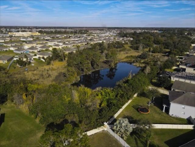 An aerial view shows a residential neighborhood surrounding a central pond and wooded area — 3810 FRIARS COVE LANE, ST CLOUD, FL