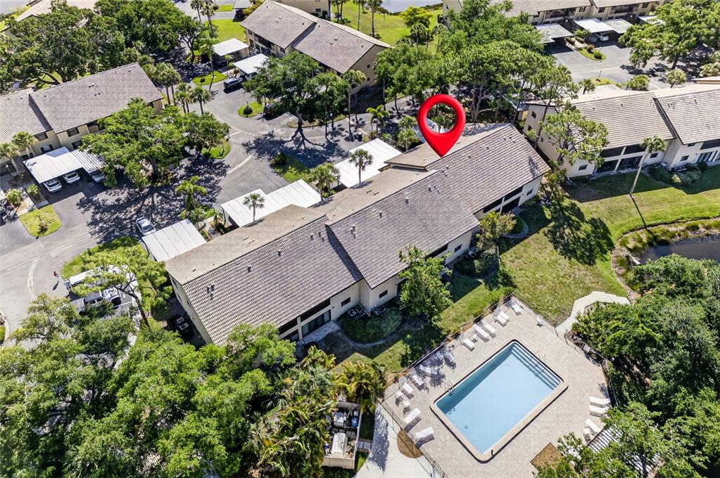 A two-story apartment building exterior features a covered carport and palm trees at dusk — 360 THREE LAKES LANE UNIT J, VENICE, FL