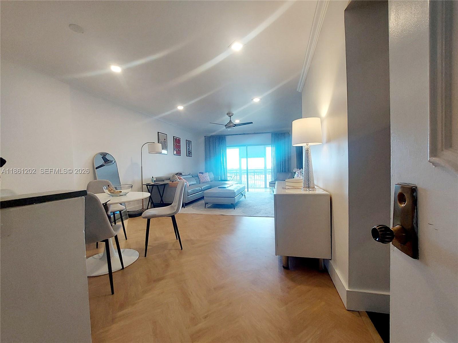A living and dining area features light wood flooring, a grey sectional, and a balcony — 4400 Hillcrest Dr # 1005A, Hollywood FL 33021, HOLLYWOOD, FL