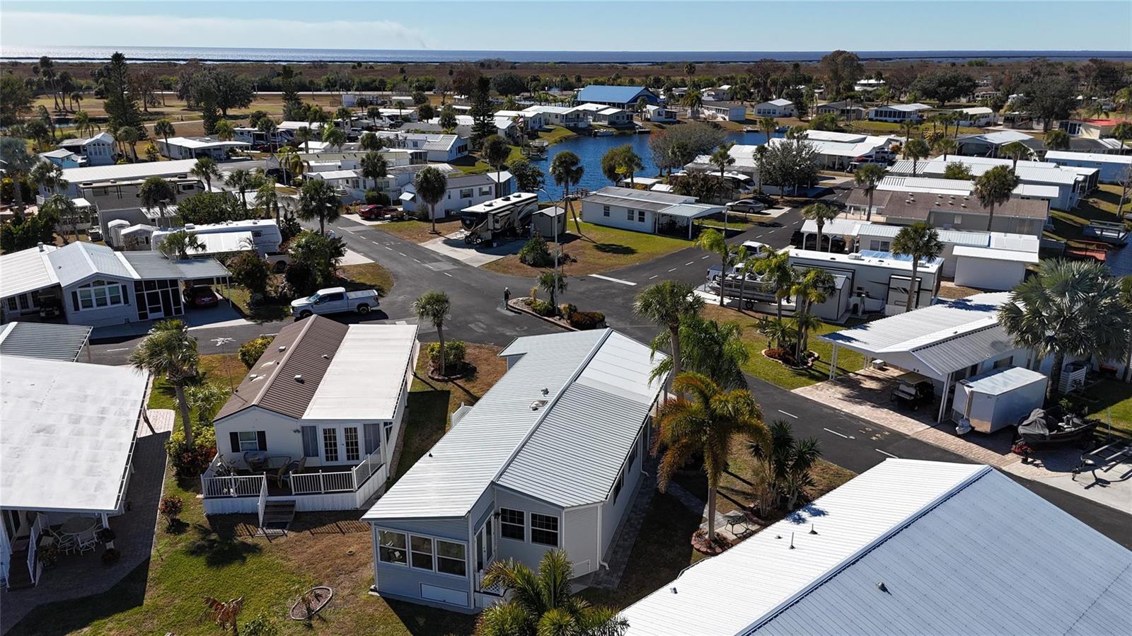 An aerial view shows a residential community of mobile homes near a body of water — 12470 SE 140th Road, Okeechobee FL 34974, OKEECHOBEE, FL
