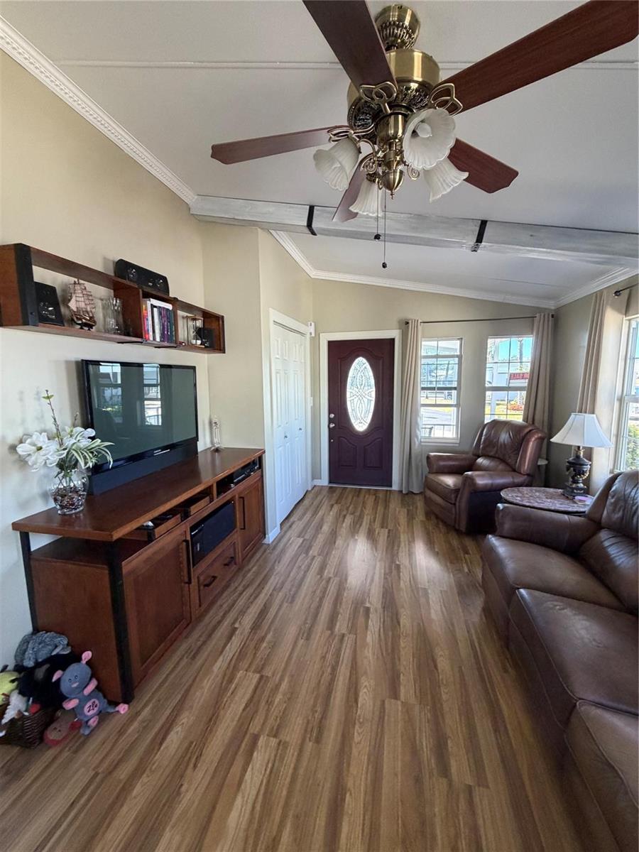 A living room features wood-look flooring, a ceiling fan, a television console, and leather furniture — 12470 SE 140th Road, Okeechobee FL 34974, OKEECHOBEE, FL