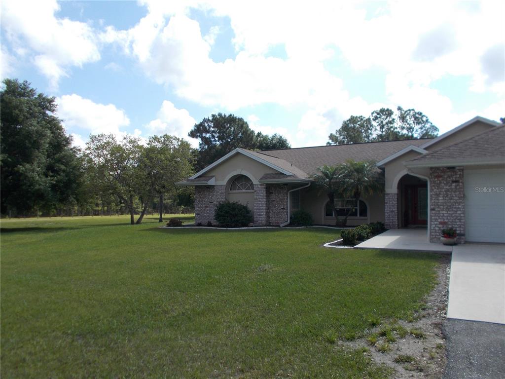 A single-story house with a brick facade, arched window, and a paved driveway — 6960 MALTON STREET, NORTH PORT, FL