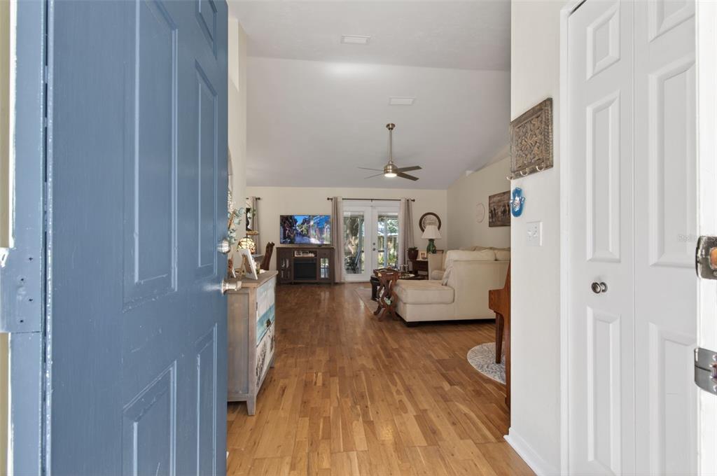 A view from an open blue door into a living room with hardwood floors — 6146 NW 38TH TERRACE, GAINESVILLE, FL