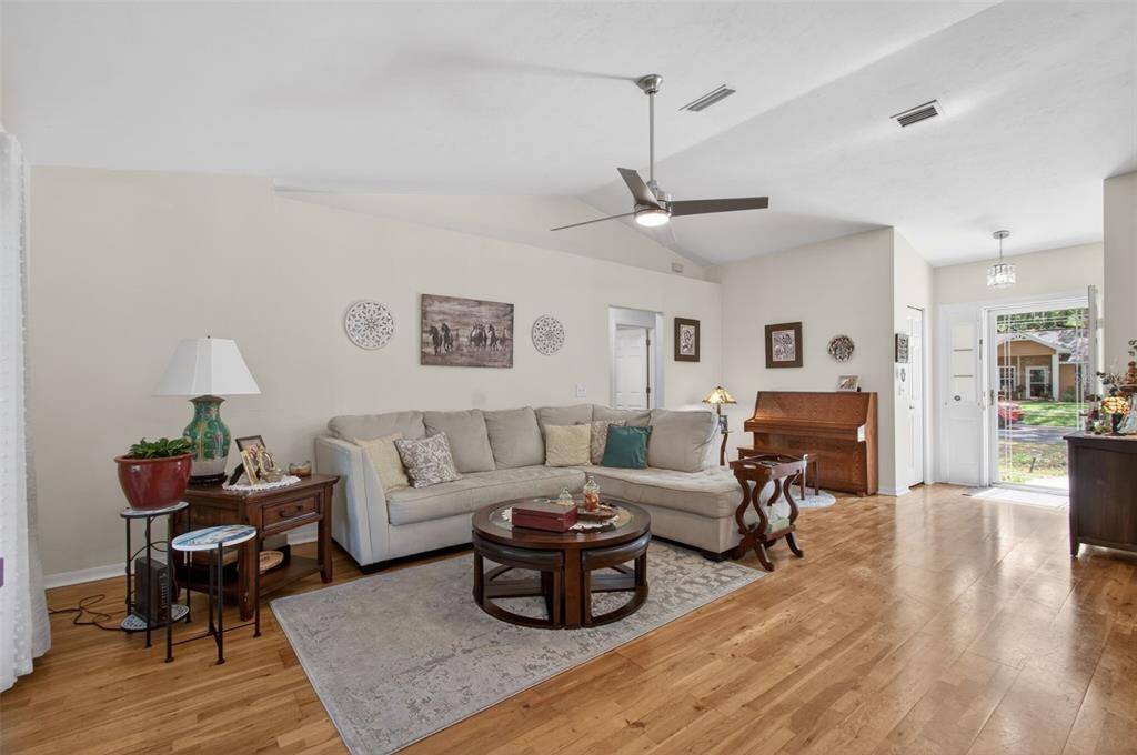 A living room features a sectional sofa, a round coffee table, and hardwood flooring — 6146 NW 38TH TERRACE, GAINESVILLE, FL