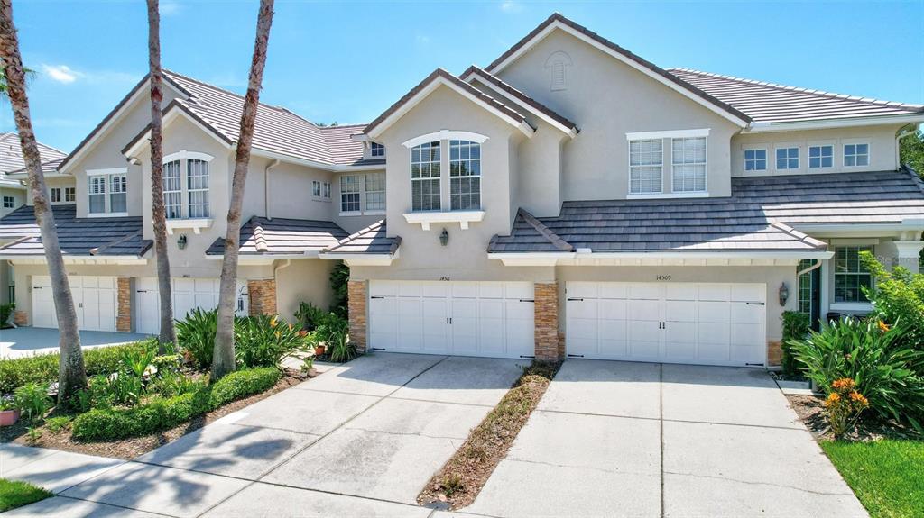 A front porch with a gray door, a window with shutters, and a wicker chair — 14511 MIRABELLE VISTA CIRCLE, TAMPA, FL