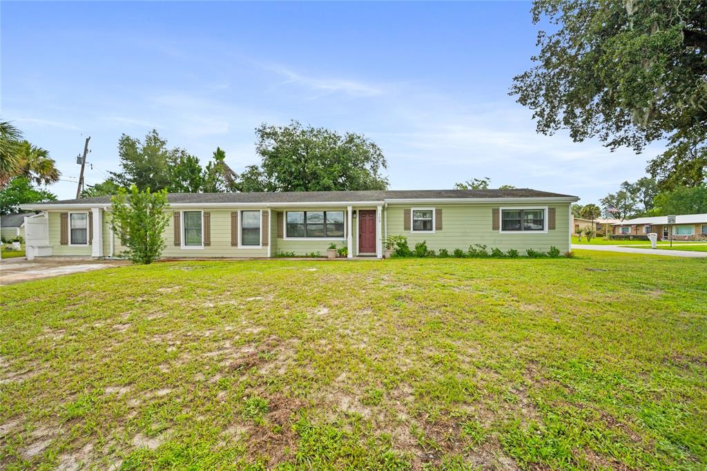 A single-story light green house with a dark red front door and a grassy yard — 105 MIRROR DRIVE, SANFORD, FL
